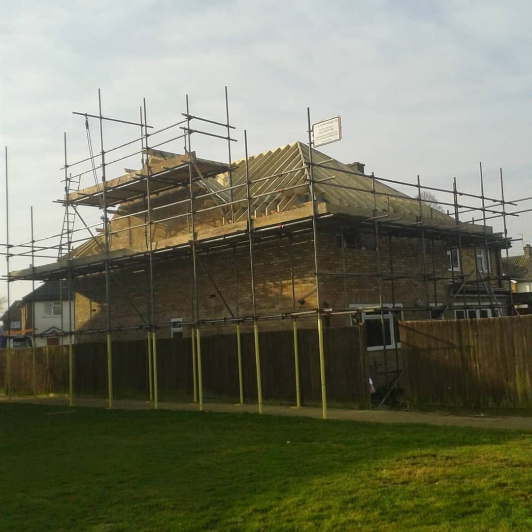 Detached house with full perimeter scaffold supporting a new timber pitched roof structure